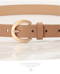 Gros plan d'une fine ceinture en cuir camel avec une boucle fer à cheval dorée polie