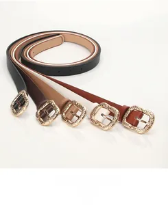 Detail showing five assorted leather belts with textured square alloy buckles on white surface
