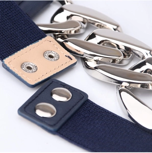 Détail d'une ceinture élastique bleu marine avec de larges chaînes argentées et pressions