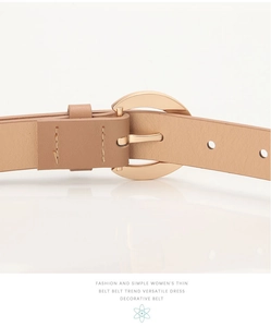 Détail d'une ceinture fine en cuir abricot avec une boucle demi-cercle en métal doré