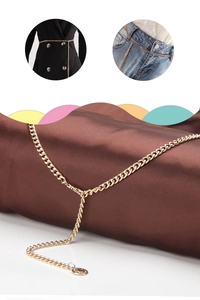 Detail of gold metal waist chain belt with round tag shown on dark silk and clothing