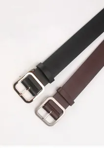 Detail of minimalist leather belts with square metal buckles in black and brown colors