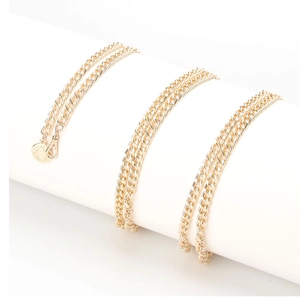 Detailed macro view of a gold cuban link chain belt with a circular Madewell metal tag