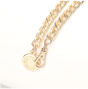 Detail of gold metal chain accessory with lobster clasp and round logo pendant