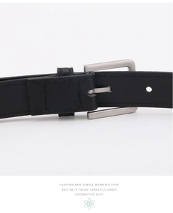 Primo piano di una cintura sottile in pelle nera minimalista con fibbia rettangolare argento