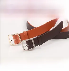 Detail of minimalist leather belts with square metal buckles in orange and brown