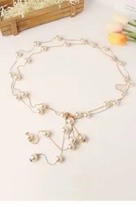 Dettaglio elegante catena in vita con perle e fili d'oro e argento per abiti da sposa
