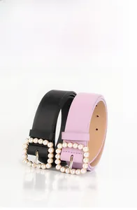 Dettaglio delle cinture in pelle PU nera e rosa con fibbie quadrate con perle