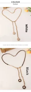 Détail de ceintures en chaîne métallique avec pendentifs fleurs en perles et cuir noir