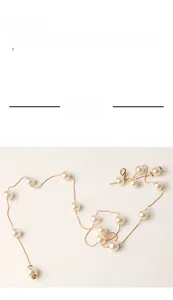 Primo piano dettagliato di una cintura a catena dorata da donna con eleganti perle bianche