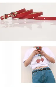 Détail de ceinture fine pour femme avec boucle dorée double anneau en rouge et noir