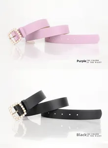 Dettaglio fibbie quadrate con perle su cinture in similpelle nera e viola per abiti