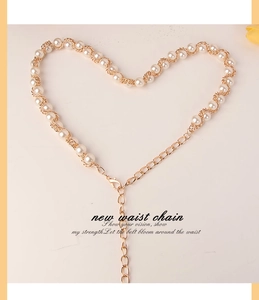 Détail d'une élégante chaîne de taille en perles avec tissage doré et forme de cœur