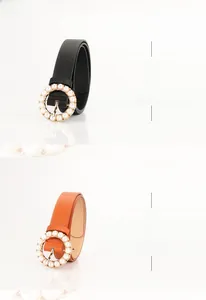 Detail of elegant round buckle belts with white pearls in black and camel leather
