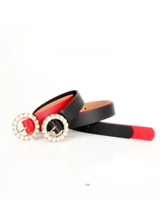 Detail of elegant black and red leather belts featuring gold round pearl buckles