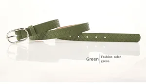 Détail d'une ceinture tressée vert foncé en cuir avec boucle métallique argentée en D