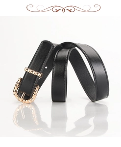 Detail of slim black PU leather belt with elegant golden bamboo-shaped metal buckle texture