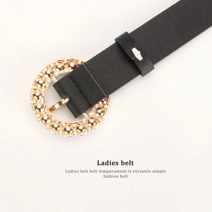 Women black leather belt with round gold buckle and pearl detail on beige backdrop