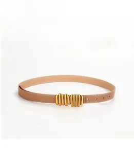 Dettaglio cintura in pelle beige con fibbia a cilindro dorata stile bruco
