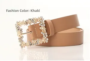 Close-up of khaki leather belt featuring a square gold buckle with rhinestones and floral detail