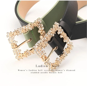 Close-up of elegant leather belts featuring gold alloy buckles with sparkling rhinestones