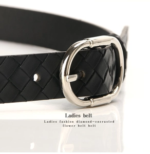 Gros plan d'une ceinture en cuir tressé noir avec une boucle ovale en métal argenté