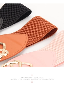 Detail von elastischen Taillengürteln in Schwarz, Braun und Rosa mit Goldschnallen