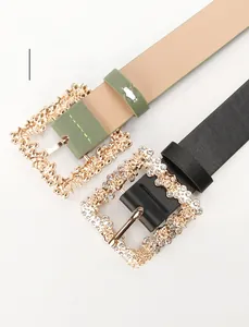 Close-up of women's PU leather belt with decorative diamond-encrusted flower buckle