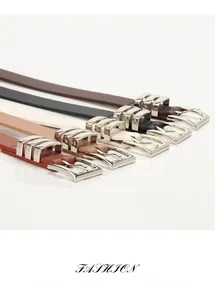 Detail of five slim fashion belts in various colors with elegant silver pin buckles