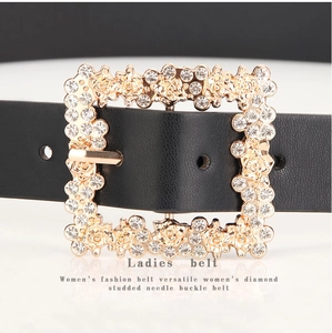 Close-up of black PU leather belt with rhinestone-studded gold rose buckle