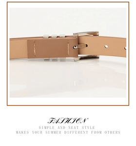Detail of light brown slim leather belt featuring silver metal buckle and fine stitching