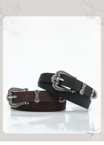 Close-up of vintage floral engraved silver buckles on black and brown leather belts