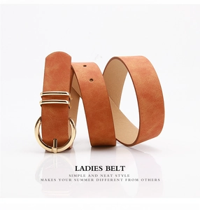 Close-up of brown leather belt for women with elegant golden round buckle on white background