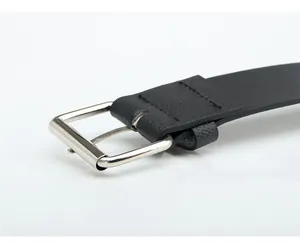 Macro detail of high-quality black leather belt with silver rectangular metal buckle