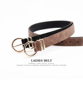 Detail of minimalist leather belts in black and brown with golden round pin buckle