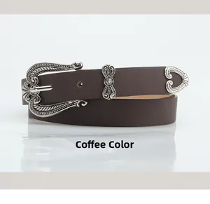 Detail view of coffee vintage belt with carved silver buckle and bohemian floral patterns