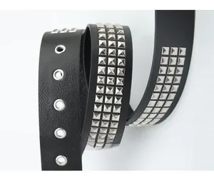 Close-up of black punk belt with three rows of silver square pyramid metal studs
