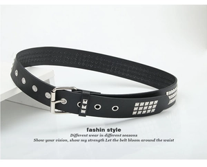 Detail of black leather punk belt with silver square studs and metal eyelets