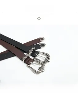 Close-up of vintage crown carved silver buckles on black and brown leather belts
