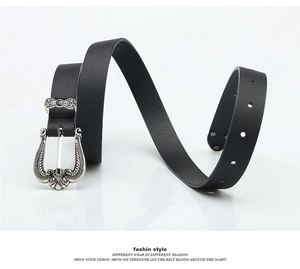 Detail of vintage silver engraved buckle on black leather belt with adjustable holes