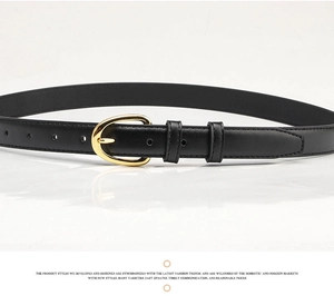 Detail of a thin black leather belt featuring a polished gold oval pin buckle for women