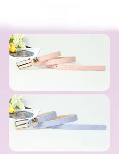Detail of pink and purple faux leather belts featuring golden wavy textured buckles