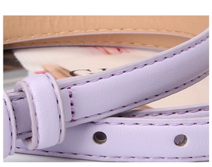 Dettaglio della sottile cintura in pelle viola chiaro con cuciture e fori regolabili