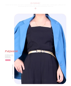 Détail d'une fine ceinture en cuir PU doré avec boucle ardillon argentée sur blazer bleu