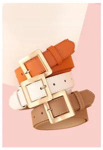 Three minimalist women belts in orange, white and brown with gold square buckles