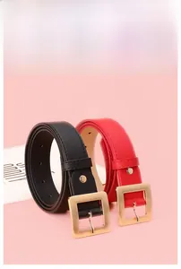 Detail view of minimalist black and red leather belts with polished gold square buckles