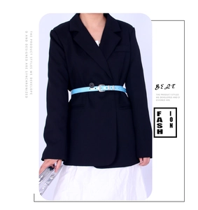 Fine ceinture bleu ciel avec boucle argentée sur un blazer noir et une robe blanche
