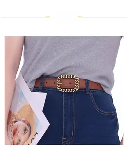 Nahaufnahme eines braunen Ledergürtels mit goldener Kettenschnalle an einer Jeans