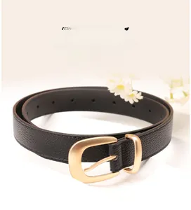Détail d'une ceinture en cuir noir avec boucle dorée mate sur des marguerites blanches