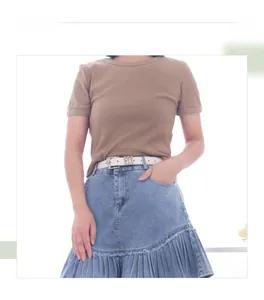 Détail d'un t-shirt côtelé café associé à une jupe en jean bleu plissée élégante